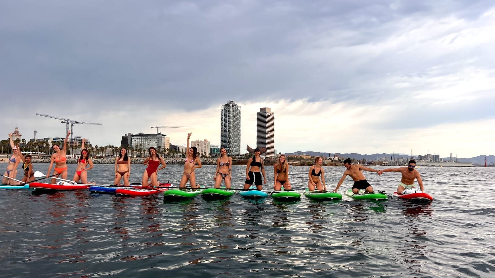 A large group paddleboarding together along the Barcelona coastline, a team building activity.